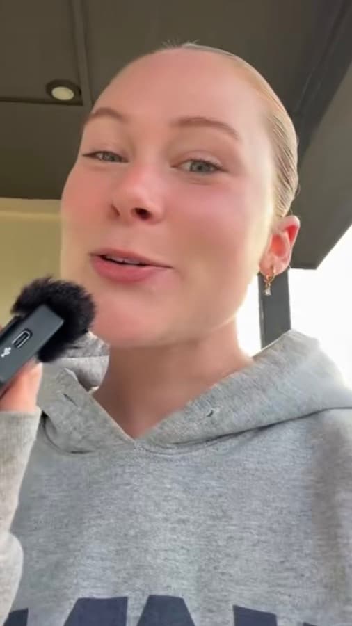 A creator speaking to camera with a handheld mic